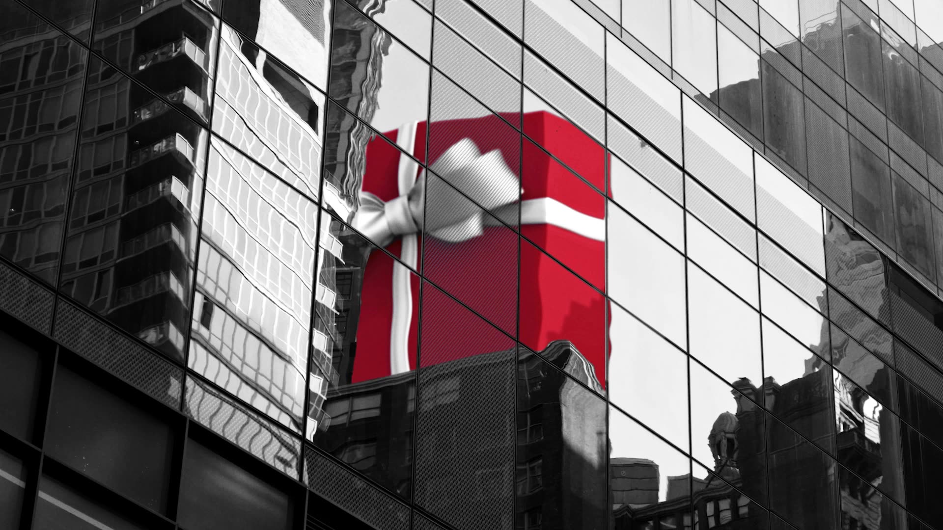 Red gift box reflected in glass building
